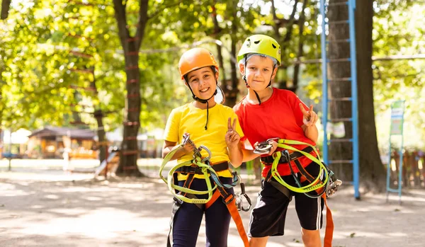 Enfant dans le parc d'aventure forestière. Les enfants grimpent sur le sentier de la corde haute. Agilité et escalade centre d'amusement extérieur pour les enfants. Petite fille jouant dehors. Cour d'école aire de jeux avec chemin de corde. — Photo