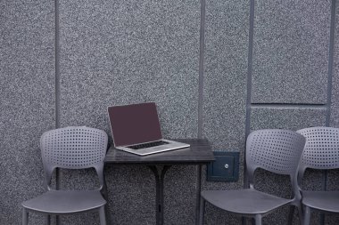 Kafedeki masada dizüstü bilgisayarla basit çalışma alanının görünümünü kapat