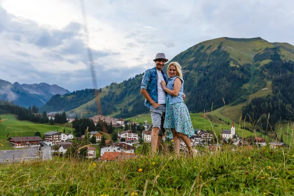 Młodzi miłośnicy relaksu na wakacjach w pięknej panoramie z górami Bawaria Niemcy. Para zakochanych relaksuje się wiosną — Zdjęcie stockowe