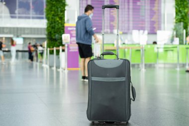 Modern havaalanı terminalinin zemininde duran bavul. Boşluğu kopyala