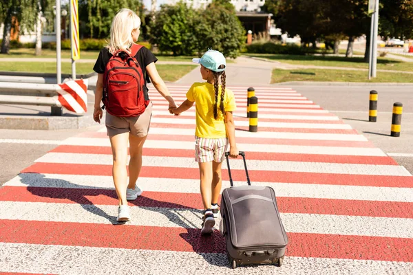 Mutter und kleine Tochter fahren mit Koffern zum Flughafen. Tourismus und Reisen. — Stockfoto