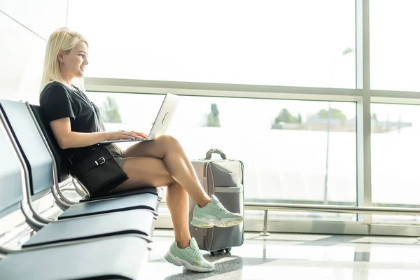 Fiatal nő segítségével a laptop számítógép repülőtéren — Stock Fotó