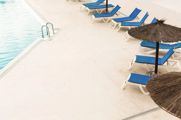 Hotel uszoda üres napozóágyakkal — Stock Fotó