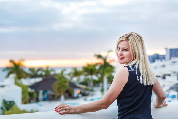 Frau entspannt sich am Pool in einem luxuriösen Strandhotel-Resort bei Sonnenuntergang und genießt perfekten Strandurlaub — Stockfoto