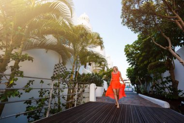 Açık havada, tropik plajda poz veren zarif bir kadının moda portresi.