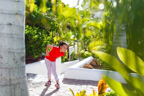 Kleines Mädchen spaziert in der Nähe von Palmen, Urlaub — Stockfoto