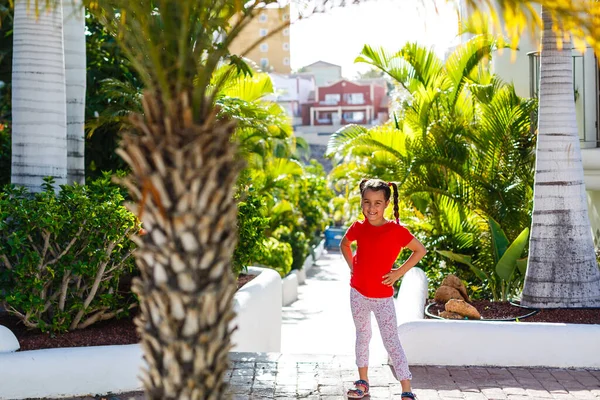 Kleines Mädchen spaziert in der Nähe von Palmen, Urlaub — Stockfoto
