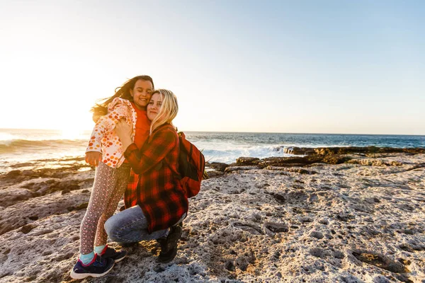 Mała dziewczynka i mama idą nad morze, bawią się i przytulają — Zdjęcie stockowe