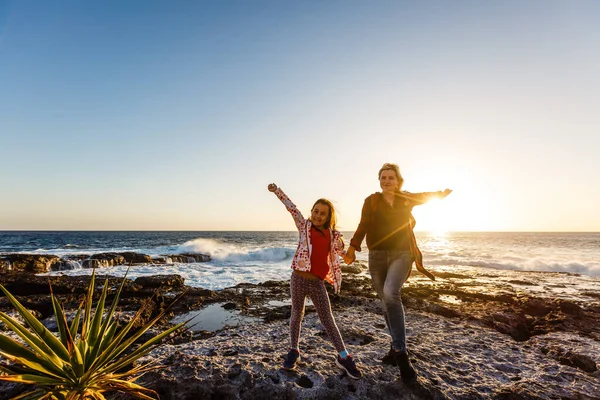 Ein kleines Mädchen und eine Mutter gehen in der Nähe des Meeres, sie spielen, im Freien — Stockfoto