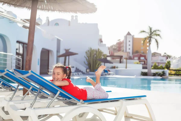 Klein meisje loopt in de buurt van palmbomen, vakantie — Stockfoto