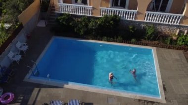 Anne ve kızı otelin havuzunda dinleniyorlar. İnsanlar tatilin tadını çıkarıyor. Ana kız gerçekliği..