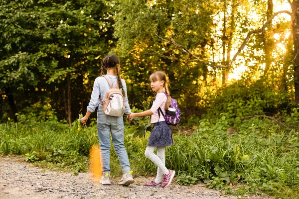 Šťastný radostné školní děti s batohy v lese na podzim den, vzrušené děti dívky baví během kempování aktivity v přírodě — Stock fotografie