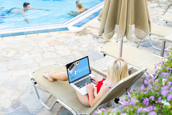 Жінка-фрілансер, туристичний блогер працює на ноутбуці. сидить на шезлонгу в саду біля басейну . — стокове фото