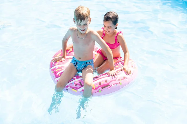 Niños divirtiéndose jugando en la piscina en las vacaciones de verano — Foto de Stock