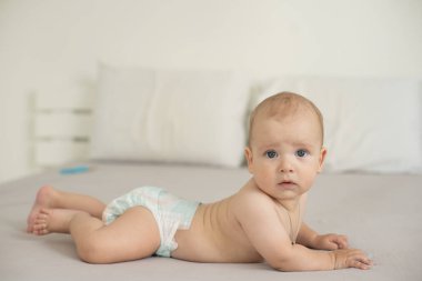 Beyaz yatak odasındaki sevimli erkek bebek. Yeni doğmuş çocuk yatakta dinleniyor. Aile sabahı evde..