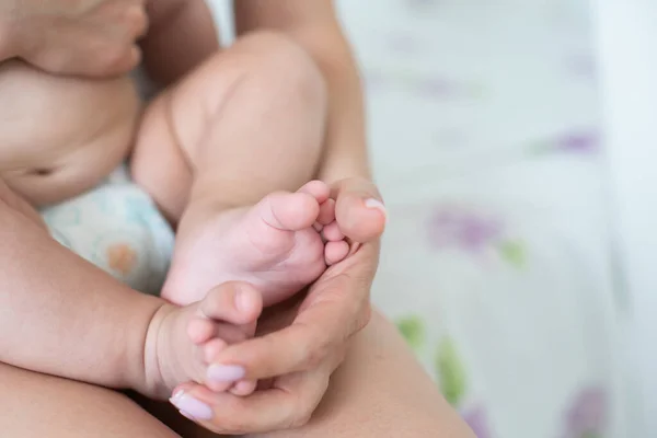 Padres sosteniendo en las manos los pies del bebé recién nacido — Foto de Stock