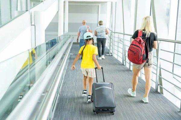 Família no aeroporto. Jovem atraente e filhinha fofa estão prontos para viajar. Conceito de família feliz. — Fotografia de Stock