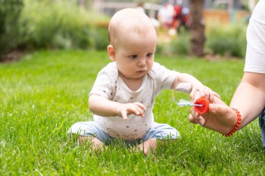 Çimlerde güzel bir bebeğin yaz portresi