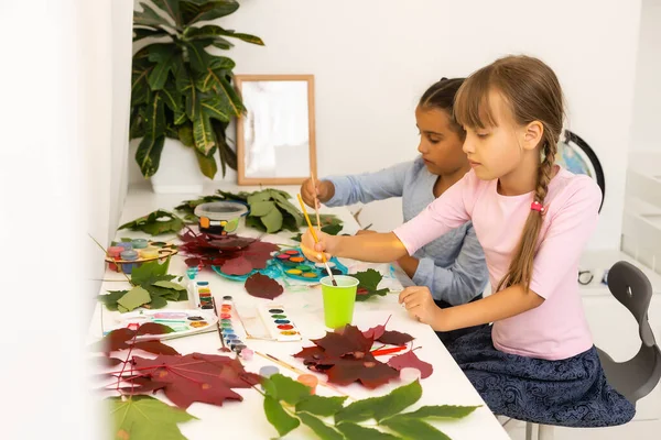 Duas alunas desenhar folhas, meninas pintar folhas de outono — Fotografia de Stock