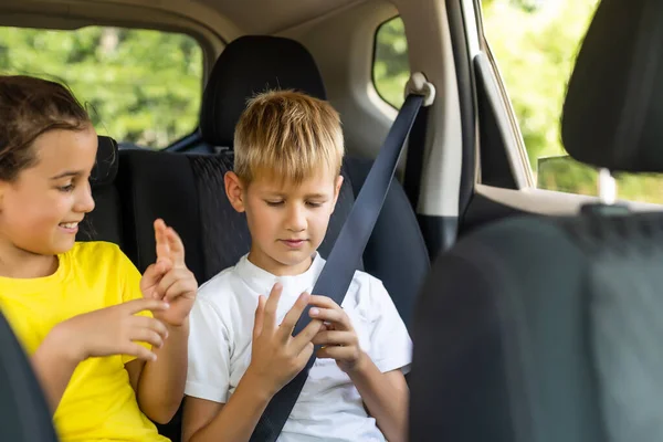 Leende barn sitter på baksätet i bilen — Stockfoto