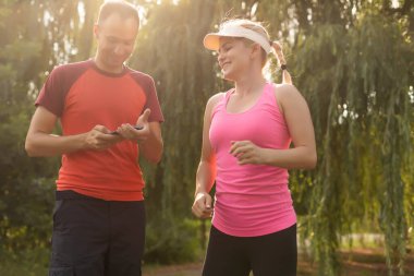 Genç çift, bir kır yolu, egzersiz ve zindelik konsepti üzerinde koşarken sağlıklı bir yaşam tarzının keyfini çıkarıyor.