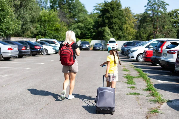 Mutter und Tochter mit Koffer auf dem Parkplatz — Stockfoto