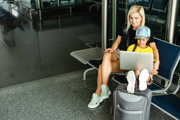 Laptop havaalanında çalışan anne kız. — Stok fotoğraf