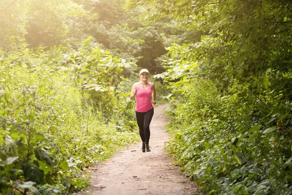 Kırsal bir yolda koşan genç bayan.