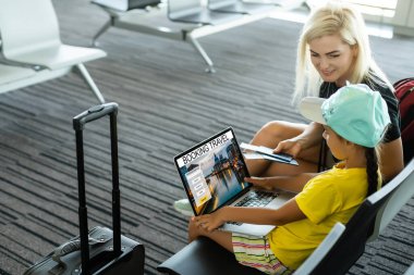 Havaalanında birlikte seyahat eden mutlu bir anne ve kız.