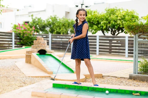 Menina bonito jogar mini golfe em um parque — Fotografia de Stock