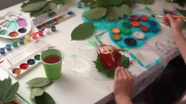Twee schoolmeisjes trekken bladeren, meisjes schilderen herfstbladeren — Stockvideo