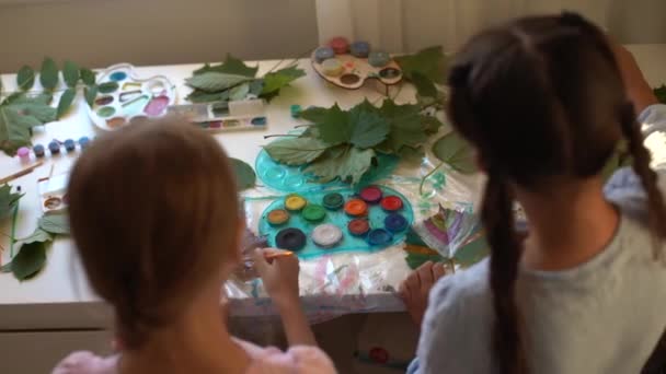 Dos colegialas pintan las hojas — Vídeos de Stock