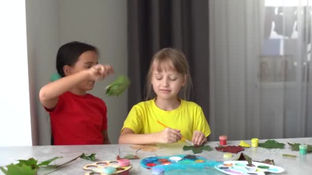 Niño pintando hojas de otoño en casa — Vídeos de Stock