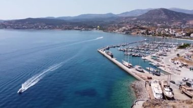 Parasailing, Parasailing Bir Teknenin Arkasında. Adam bir paraşütle denizin üzerinde uçuyor. Dağın arka planındaki tekneye bir ip bağlıyor.