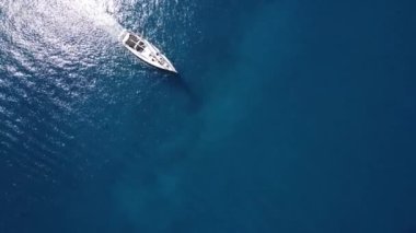 Parasailing, Parasailing Bir Teknenin Arkasında. Adam bir paraşütle denizin üzerinde uçuyor. Dağın arka planındaki tekneye bir ip bağlıyor.