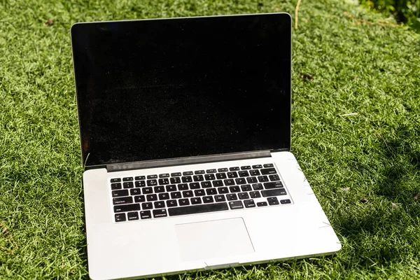 Laptop op groen gras. laptop in de tuin. — Stockfoto