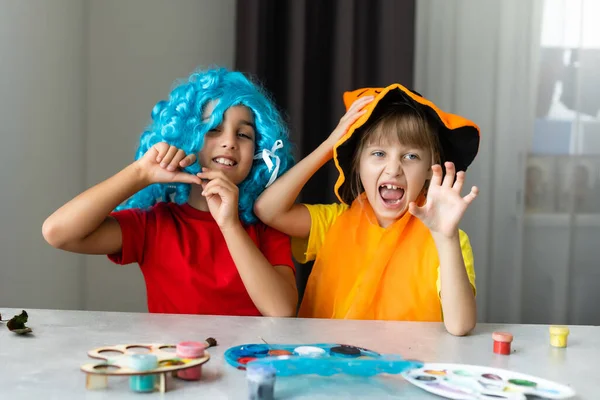 Dvě malé holčičky vyrábějící řemesla z podzimních listí na Halloween doma — Stock fotografie