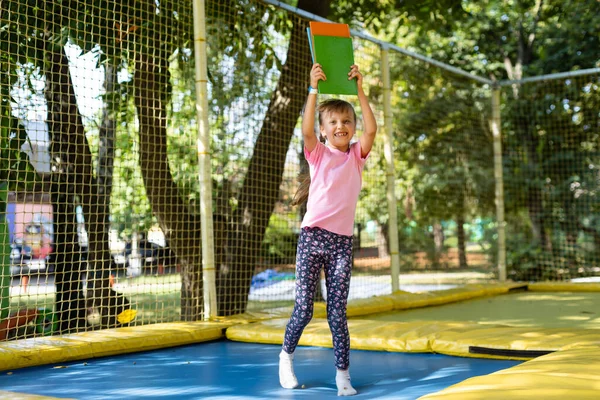 Małe dziecko lubi skoki na trampolinie - poza w podwórku — Zdjęcie stockowe