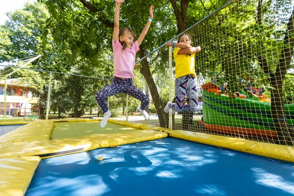 Little child enjoys jumping on trampoline - outside in backyard — Stock Photo, Image