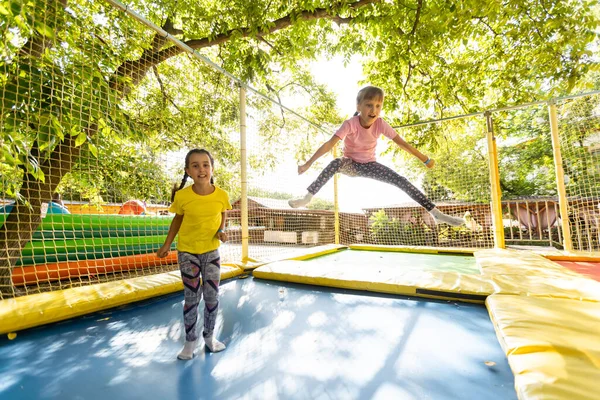 Crianças felizes pulando no trampolim — Fotografia de Stock