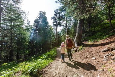 Anne ve çocuklara dağların eteklerinde yürüyüşe çıkmalarına.
