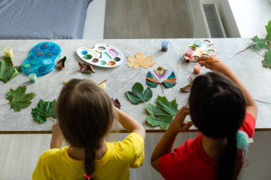 Sonbahar yapraklarını evde boyayan çocuk