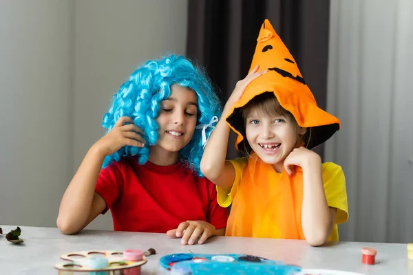 Halloween-Stimmung. zwei kleine Mädchen bereiten sich auf das Fest vor, schneiden Dekorationen, machen Herbstblätter — Stockfoto