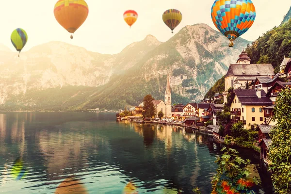 五彩缤纷的热气球飞过被群山环绕的湖面.巨大的多色气球在蓝天的映衬下缓慢升起。旅行、冒险、节庆. — 图库照片