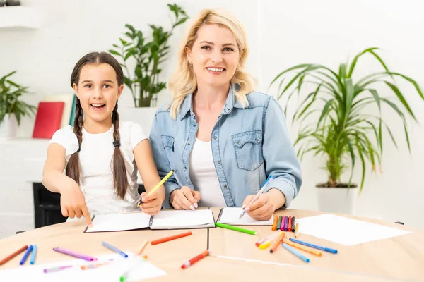 Anne ve kızı evde resim çizerek vakit geçiriyorlar.