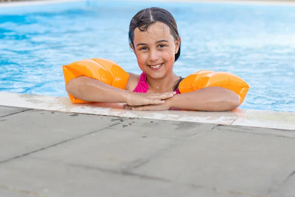 Jolie petite fille nageant dans la piscine extérieure et s'amuser — Photo