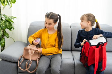 Sırt çantalı iki küçük kız çocuğunun portresi.