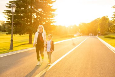 Anne kızını okula götürüyor.