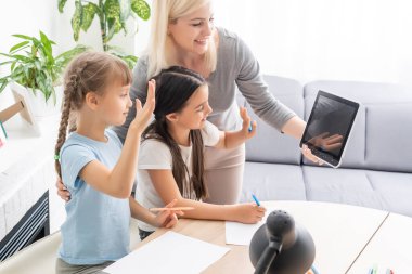 İnternette internet öğrenen iki küçük kız çocuğu annelerinin yardımıyla bilgisayar kullanarak, öğreterek ve teşvik ederek ev ödevi yapıyor. Kız ve kız kardeş evde birlikte eğitim almaktan mutlular.