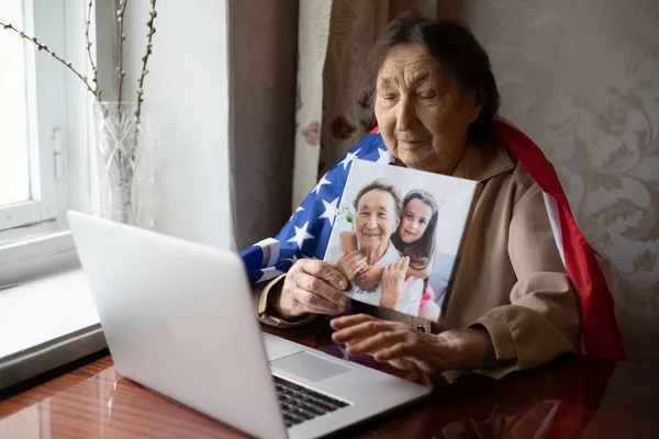 Senior woman with American flag sitting at home — Stock Photo, Image